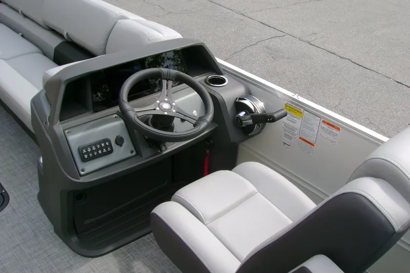 Slide: The Image of 2026 Sun Tracker Party Barge 24 XP3 helm with steering wheel and controls. - 13