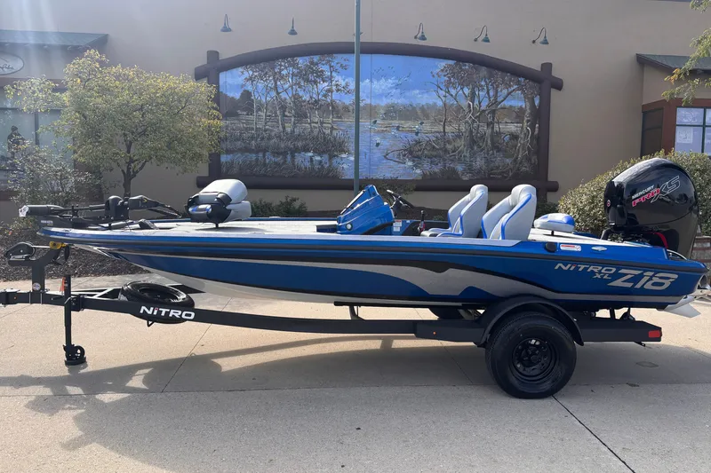 Slide: The Image of 2027 Nitro Z18 XL boat on trailer, parked outdoors with scenic mural backdrop. - 1