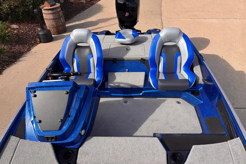 Slide: The Image of 2027 Nitro Z18 XL boat interior with blue and gray seats, parked on pavement. - 5