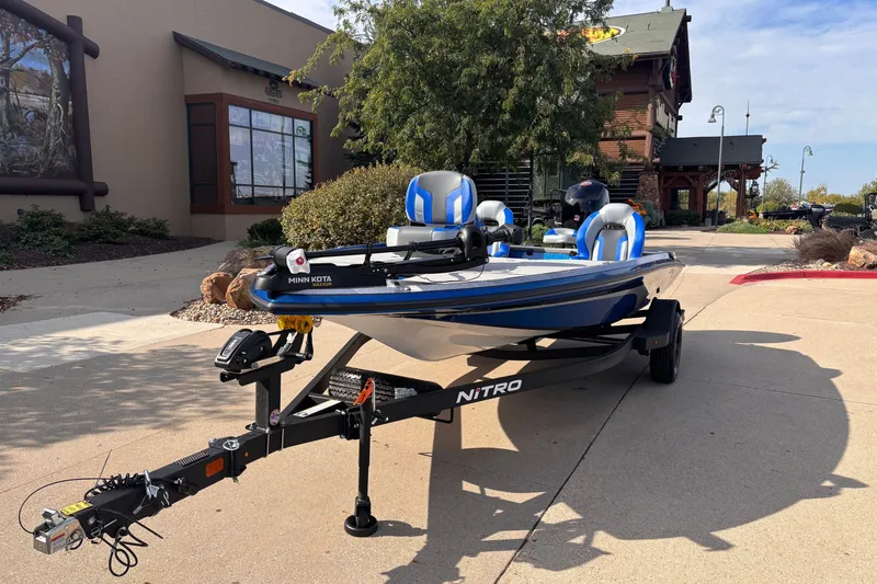 Slide: The Image of 2027 Nitro Z18 XL boat on trailer, parked outside a building. - 2