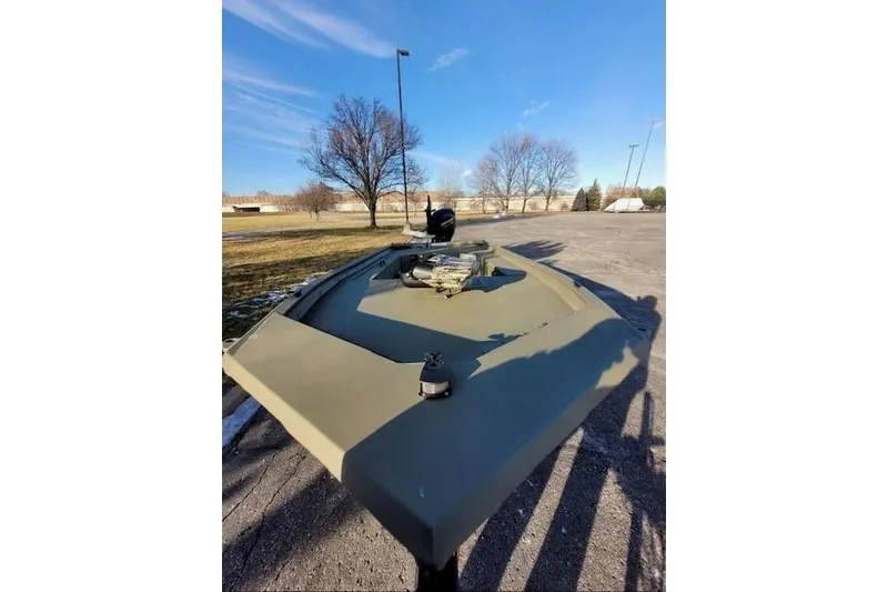 Slide: The Image of 2027 Tracker Grizzly 1654 T Sportsman boat parked outdoors on a sunny day. - 39