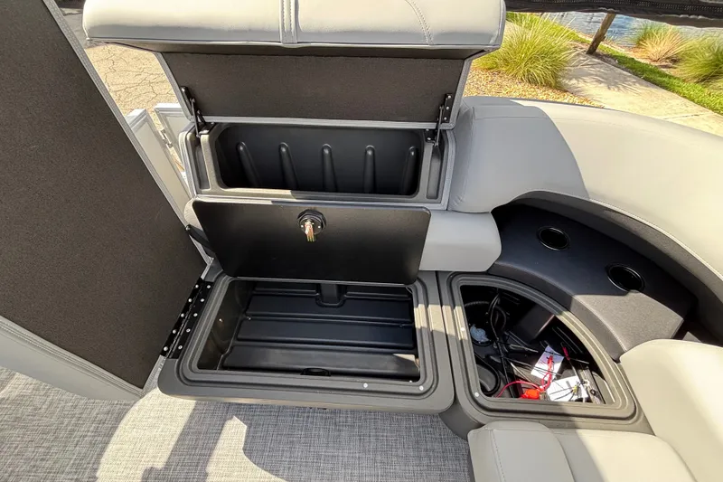 Slide: The Image of 2027 Sun Tracker Party Barge 20 DLX storage compartments with open lids, showcasing interior space. - 17