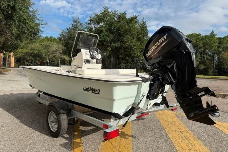Slide: The Image of 2026 Mako Pro Skiff 13 CC boat with Mercury engine on trailer, parked outdoors. - 8