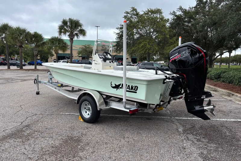 Slide: The Image of 2026 Mako 18 Pro Skiff boat on trailer in parking lot, featuring Mercury engine. - 7