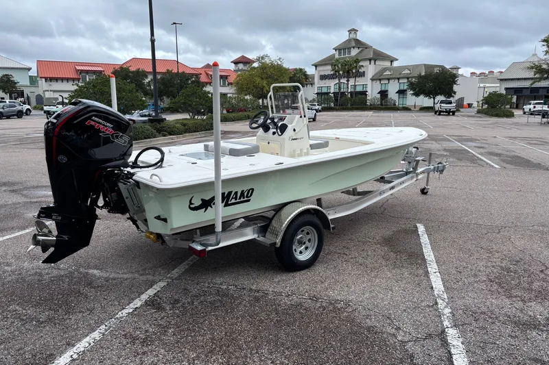 Slide: The Image of 2026 Mako 18 Pro Skiff boat on trailer in parking lot. - 2