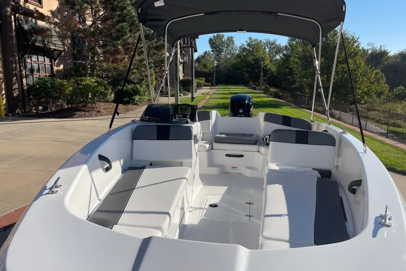 Slide: The Image of 2027 Tahoe T18 boat with spacious seating and canopy, parked outdoors on a sunny day. - 4