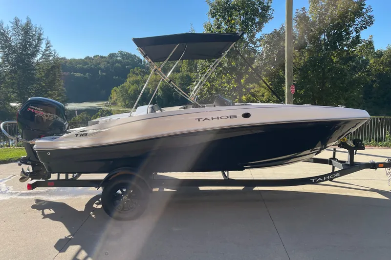 Slide: The Image of 2027 Tahoe T18 boat on trailer, parked outdoors with scenic background. - 1