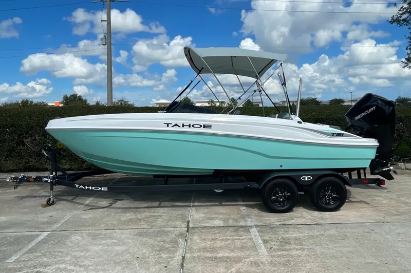 Slide: The Image of 2027 Tahoe T21 boat on trailer, turquoise hull, parked outdoors under blue sky. - 1