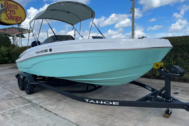 Slide: The Image of 2027 Tahoe T21 boat on trailer at Bass Pro Shops under blue sky. - 5