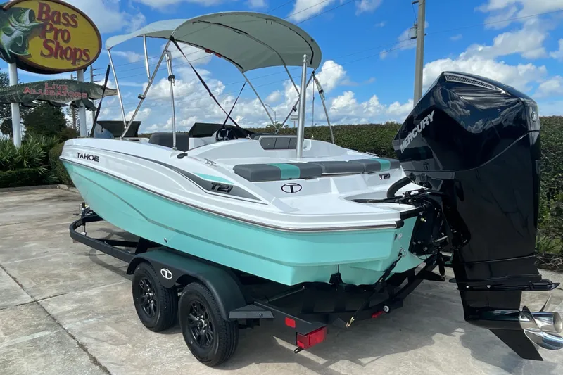 Slide: The Image of 2027 Tahoe T21 boat with Mercury engine at Bass Pro Shops under blue sky. - 3