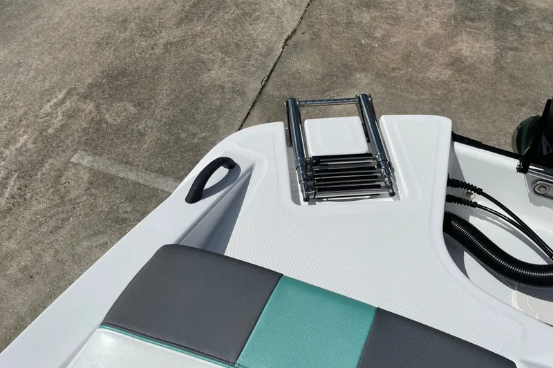Slide: The Image of 2027 Tahoe T21 boat with a foldable ladder and cushioned seating. - 29