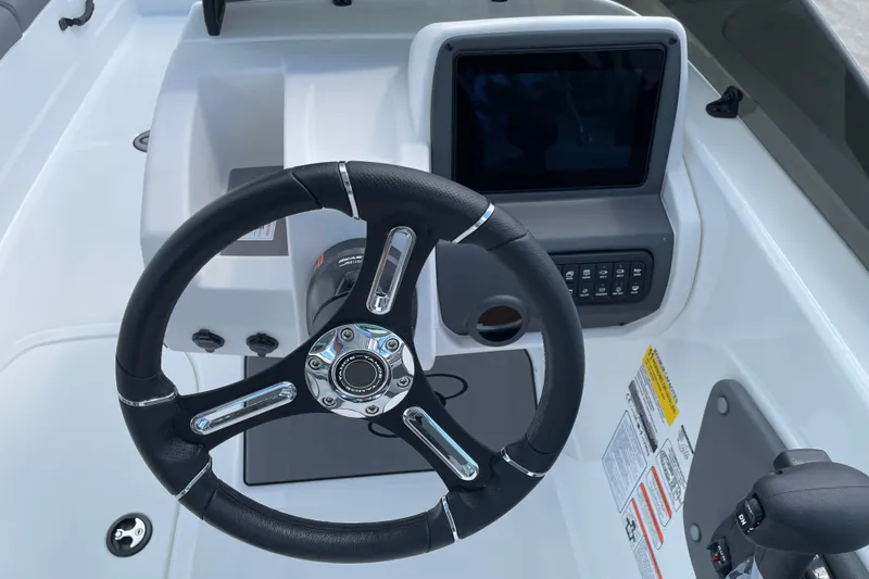 Slide: The Image of Steering wheel and dashboard of 2027 Tahoe T21 boat, featuring modern controls and display. - 11