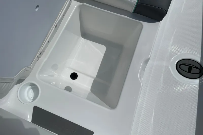 Slide: The Image of 2027 Tahoe T21 boat interior storage compartment with cup holder and drain plug. - 24