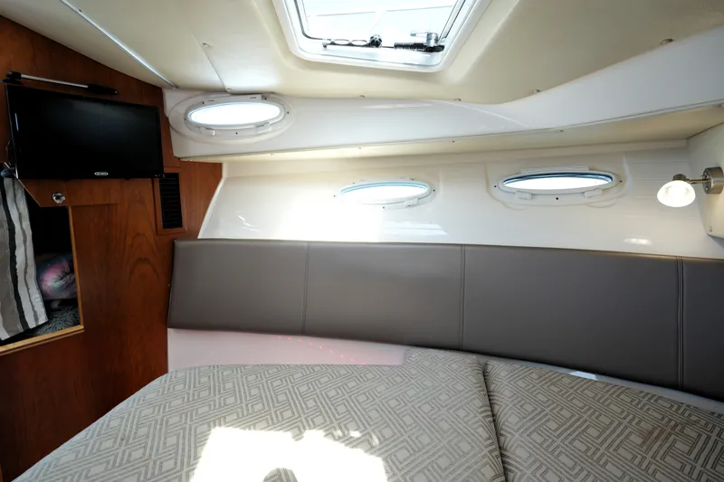 Slide: The Image of 2021 Cutwater C-32 CB cabin interior with bed, portholes, and TV. - 44