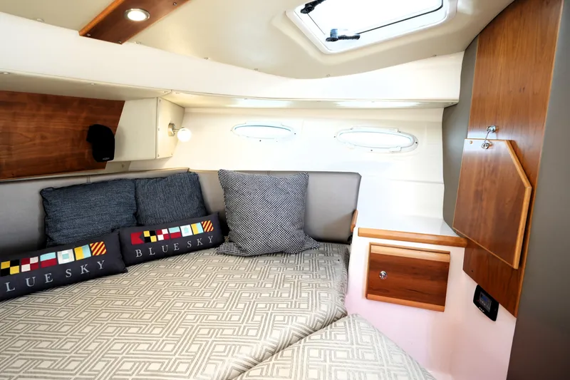 Slide: The Image of 2021 Cutwater C-32 CB cabin interior with cozy bedding and wooden cabinetry. - 46