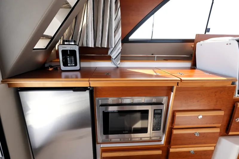 Slide: The Image of 2021 Cutwater C-32 CB interior kitchen with microwave, fridge, and coffee maker. - 29