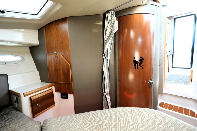 Slide: The Image of Interior of 2021 Cutwater C-32 CB boat with wooden cabinetry and restroom door. - 47
