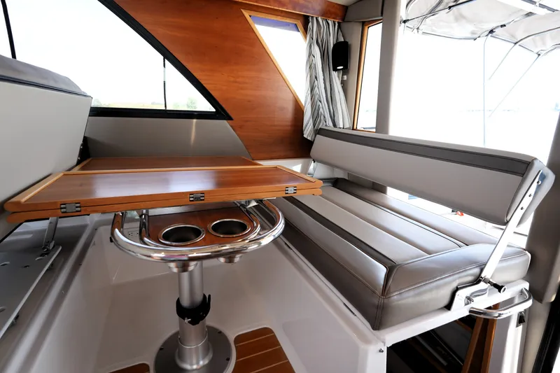 Slide: The Image of 2021 Cutwater C-32 CB interior with sleek seating and wooden table. - 35