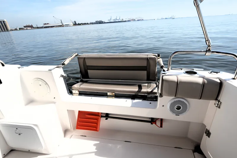 Slide: The Image of 2021 Cutwater C-32 CB boat interior with seating, overlooking calm waters and distant industrial skyline. - 18