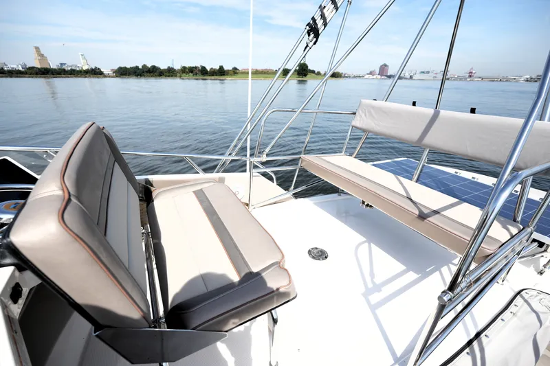 Slide: The Image of 2021 Cutwater C-32 CB boat deck with seating, overlooking calm waters and distant shoreline. - 27