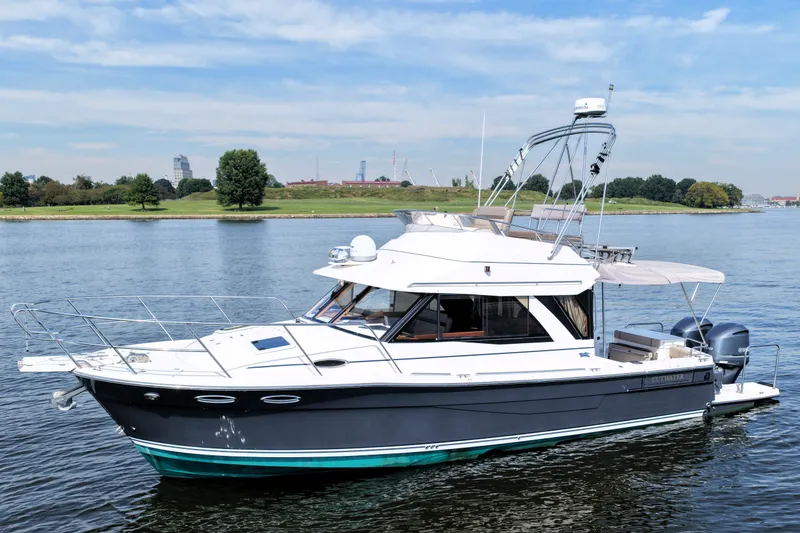 The Image of 2021 Cutwater C-32 CB boat on calm water with scenic background. - 0