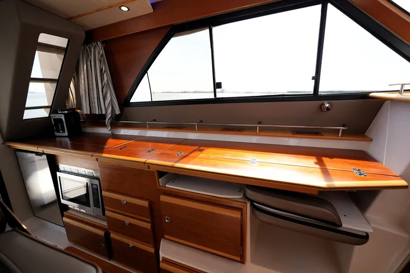 Slide: The Image of Interior of 2021 Cutwater C-32 CB boat with wooden cabinetry and modern appliances. - 32