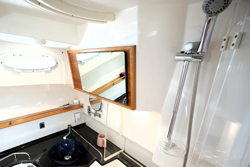 Slide: The Image of 2021 Cutwater C-32 CB yacht bathroom with modern sink, mirror, and showerhead. - 49