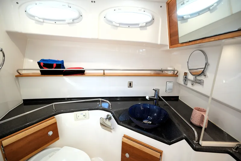 Slide: The Image of 2021 Cutwater C-32 CB yacht bathroom with modern sink, mirror, and storage shelf. - 48