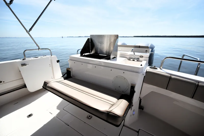 Slide: The Image of 2021 Cutwater C-32 CB boat interior with seating and grill, overlooking calm waters. - 16