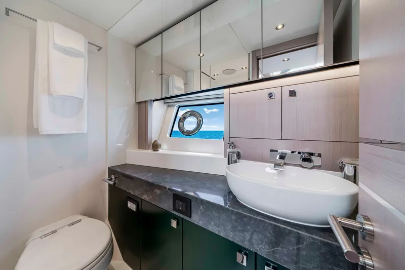 Slide: The Image of The 2027 Sunseeker Manhattan 68 bathroom features a modern sink and a window with an ocean view. - 30