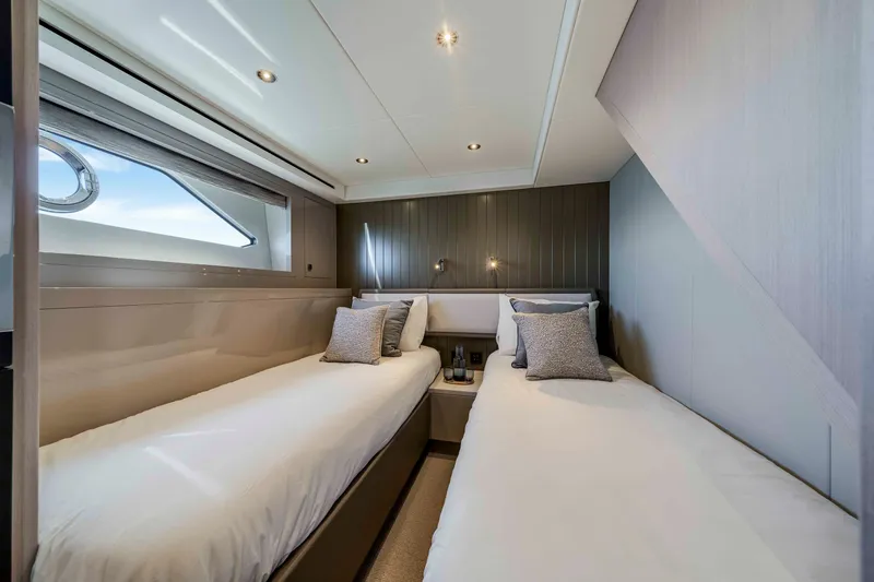 Slide: The Image of Elegant bedroom with twin beds, modern lighting, and a window overlooking the water. - 28