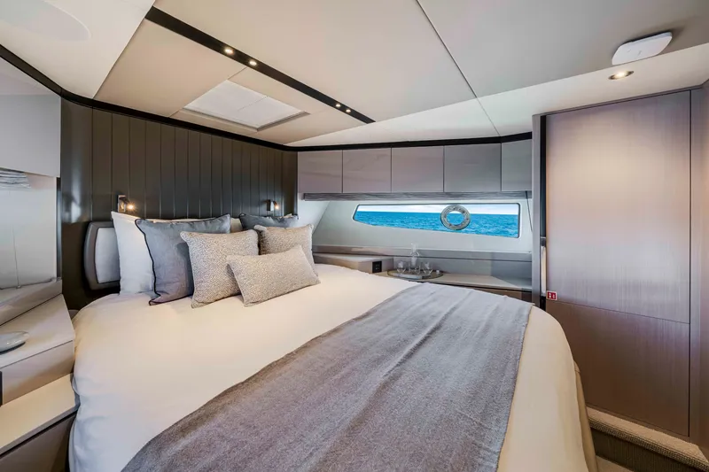 Slide: The Image of Luxurious cabin with a large bed, elegant bedding, and a window with a sea view. - 32
