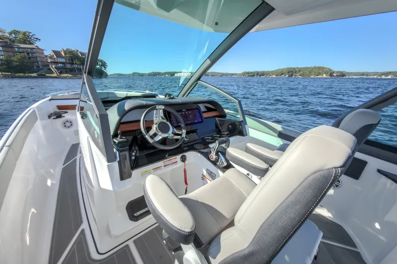 Slide: The Image of 2027 Monterey Elite 27 OB boat interior with steering wheel, dashboard, and lake view. - 45