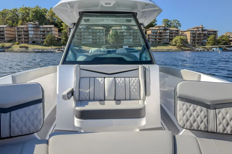 Slide: The Image of 2027 Monterey Elite 27 OB boat interior with luxurious seating on a scenic lake. - 62