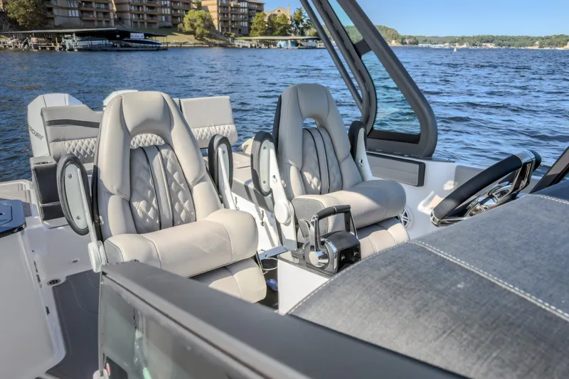Slide: The Image of Luxury seating in 2027 Monterey Elite 27 OB boat, with scenic lake view. - 68