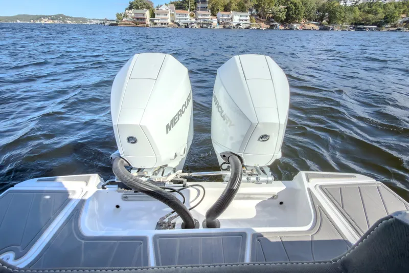 Slide: The Image of Twin Mercury outboard engines on a 2027 Monterey Elite 27 OB boat, cruising on a scenic lake. - 18