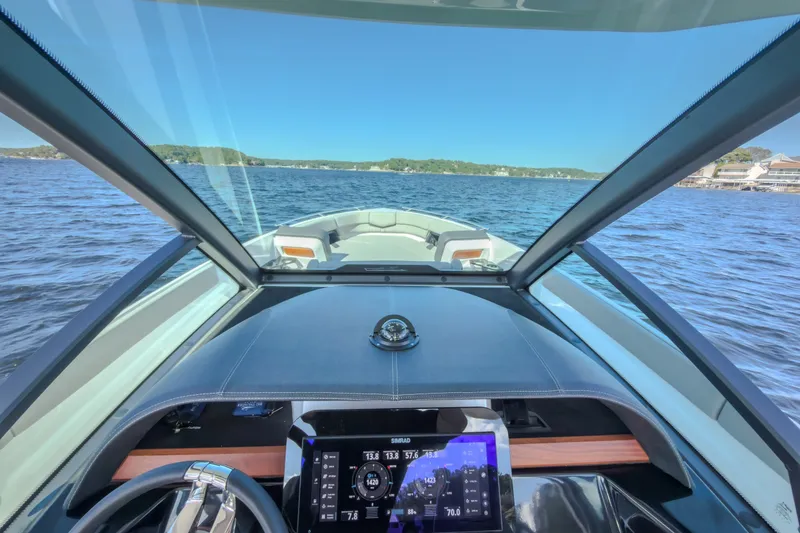Slide: The Image of Cockpit view of 2027 Monterey Elite 27 OB boat on a serene lake. - 70