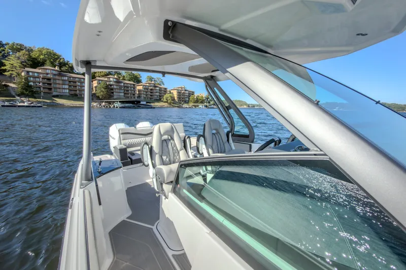 Slide: The Image of 2027 Monterey Elite 27 OB boat on a scenic lake with modern seating and sleek design. - 67