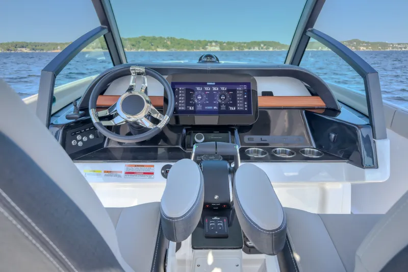 Slide: The Image of Interior view of 2027 Monterey Elite 27 OB boat cockpit with modern steering and controls. - 77