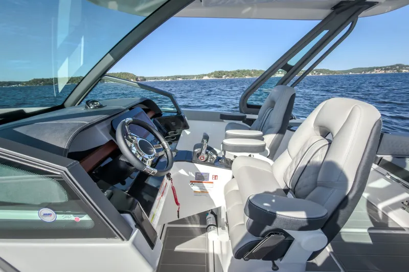 Slide: The Image of 2027 Monterey Elite 27 OB boat interior with luxurious seating and modern dashboard on a sunny day. - 40