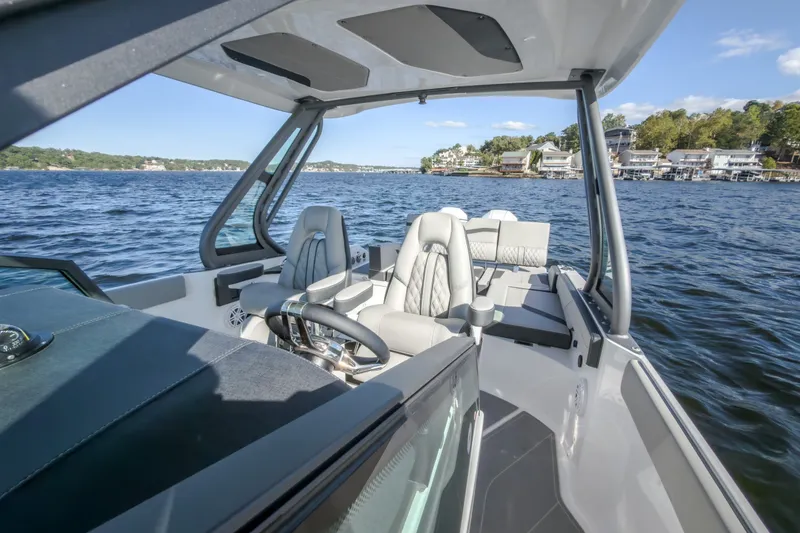 Slide: The Image of 2027 Monterey Elite 27 OB boat interior on a scenic lake. - 50