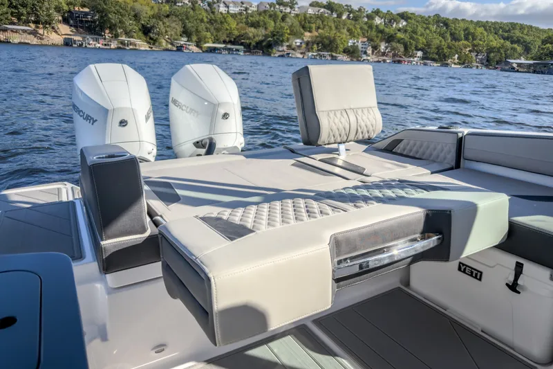 Slide: The Image of 2027 Monterey Elite 27 OB boat with luxurious seating and dual Mercury engines on a scenic lake. - 35