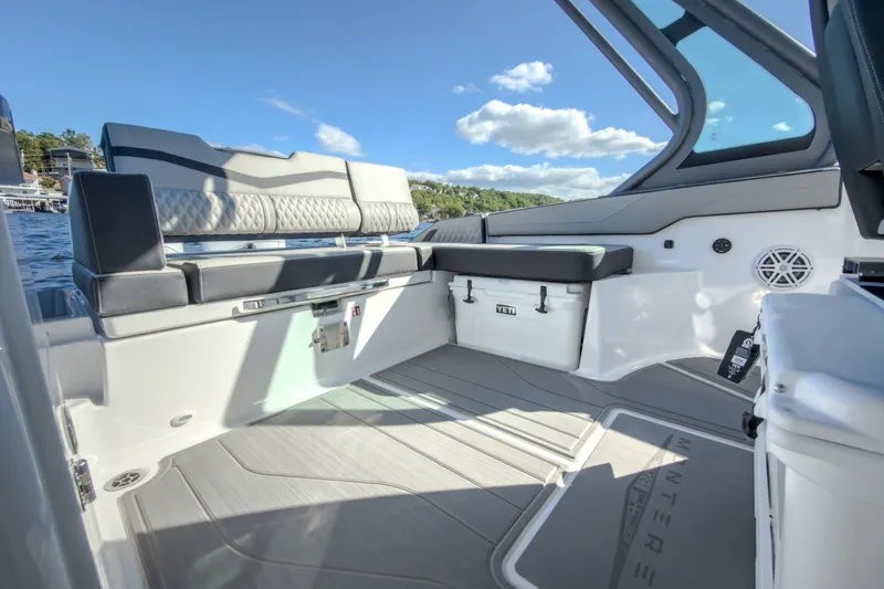 Slide: The Image of 2027 Monterey Elite 27 OB boat interior with seating and storage, under a clear blue sky. - 15