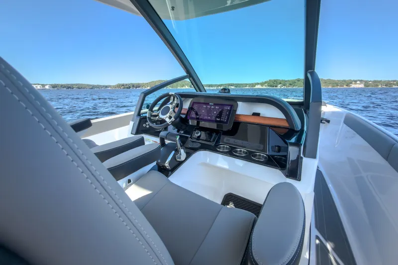 Slide: The Image of Cockpit of 2027 Monterey Elite 27 OB boat with modern controls and scenic water view. - 78