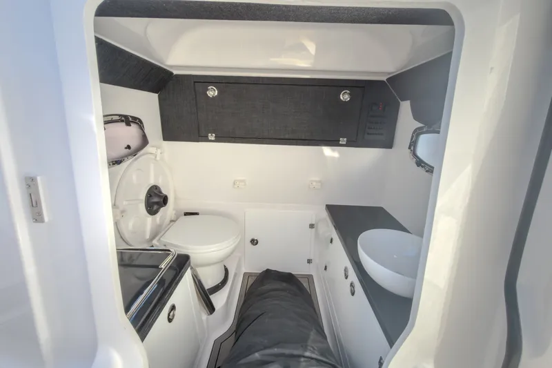Slide: The Image of Interior of 2027 Monterey Elite 27 OB boat featuring a compact bathroom setup. - 65