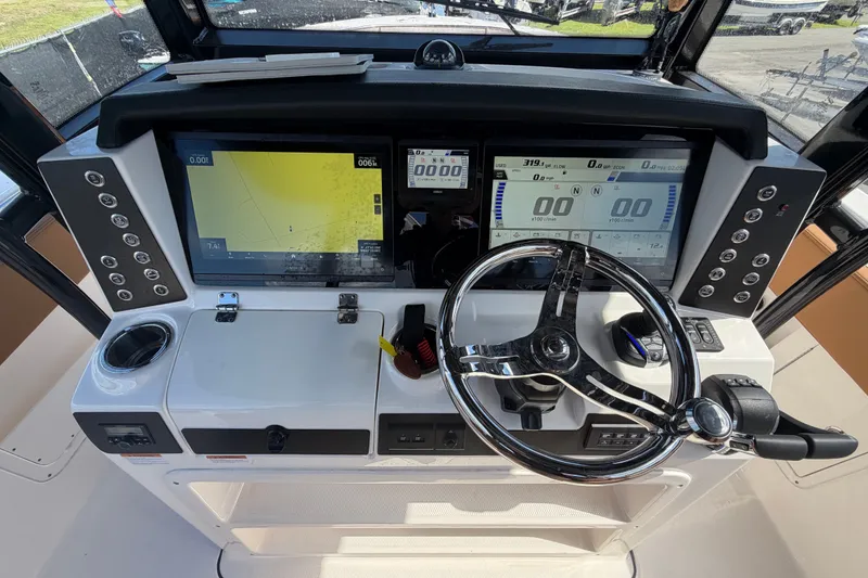 Slide: The Image of 2025 Robalo R302 Center Console dashboard with dual displays and steering wheel. - 27