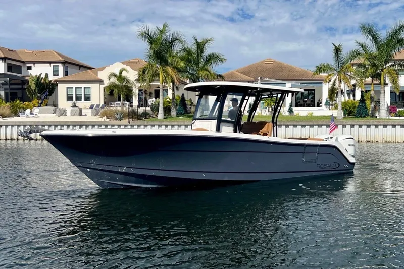 The Image of 2025 Robalo R302 Center Console boat on water near luxury waterfront homes. - 0