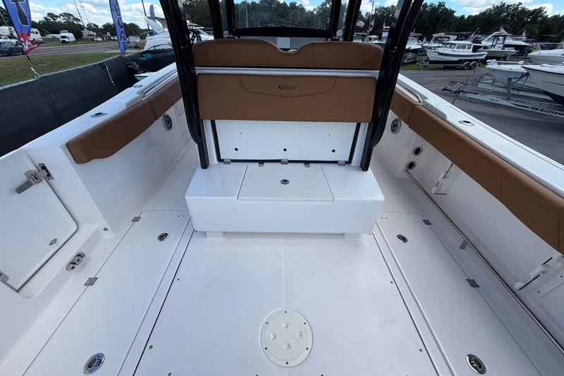 Slide: The Image of 2025 Robalo R302 Center Console boat interior with brown seating and white deck. - 18