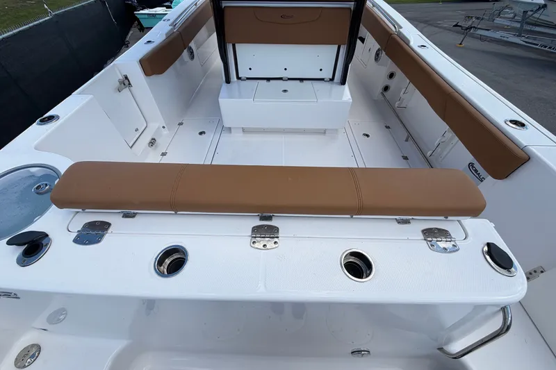 Slide: The Image of 2025 Robalo R302 Center Console boat interior with tan seating and multiple rod holders. - 16