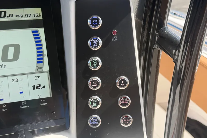 Slide: The Image of Control panel of 2025 Robalo R302 Center Console boat with various function buttons. - 32